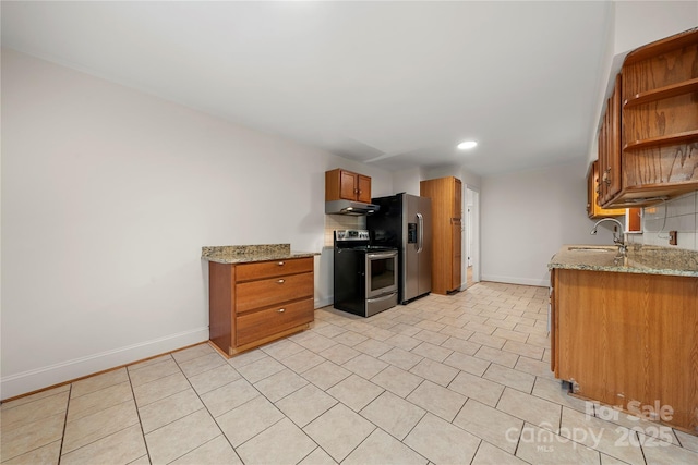 kitchen featuring light stone countertops, backsplash, stainless steel appliances, and sink