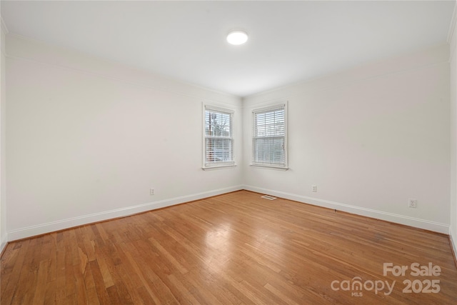 unfurnished room featuring ornamental molding and hardwood / wood-style flooring