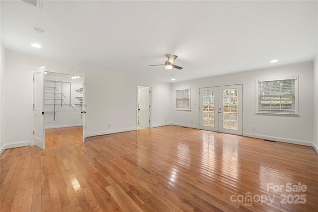 unfurnished room featuring french doors, light wood-type flooring, and ceiling fan