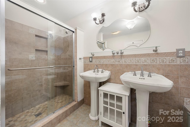 bathroom with an enclosed shower, tile patterned floors, and tile walls