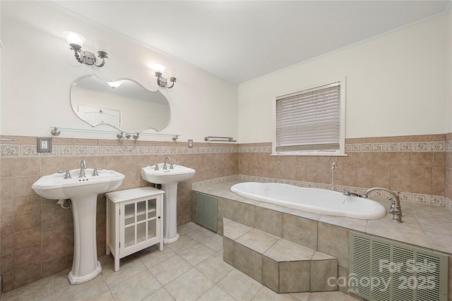 bathroom featuring tile patterned floors, a washtub, double sink, and tile walls