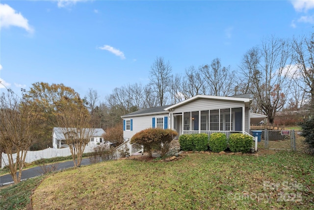 view of front facade with a front yard and a sunroom