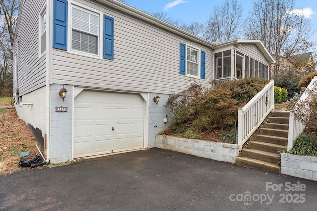 view of front of house featuring a sunroom and a garage