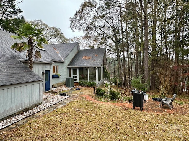 view of yard with central AC and a sunroom