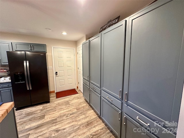 kitchen with refrigerator with ice dispenser, wooden counters, gray cabinetry, and light hardwood / wood-style flooring