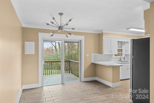 kitchen with sink, an inviting chandelier, stainless steel fridge, pendant lighting, and white cabinets