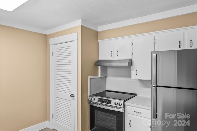 kitchen with white cabinets, ornamental molding, a textured ceiling, tasteful backsplash, and stainless steel appliances