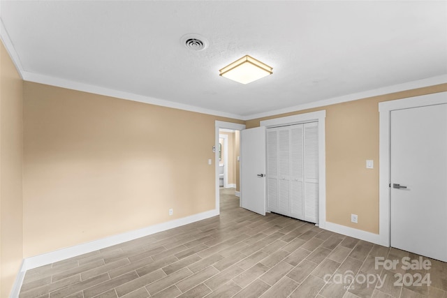 unfurnished bedroom featuring light hardwood / wood-style floors and ornamental molding