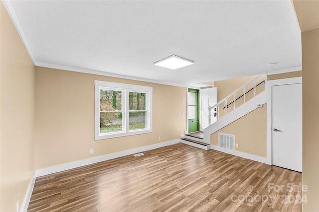 spare room with wood-type flooring and ornamental molding