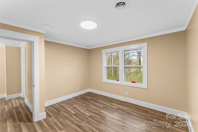 empty room featuring crown molding and hardwood / wood-style floors