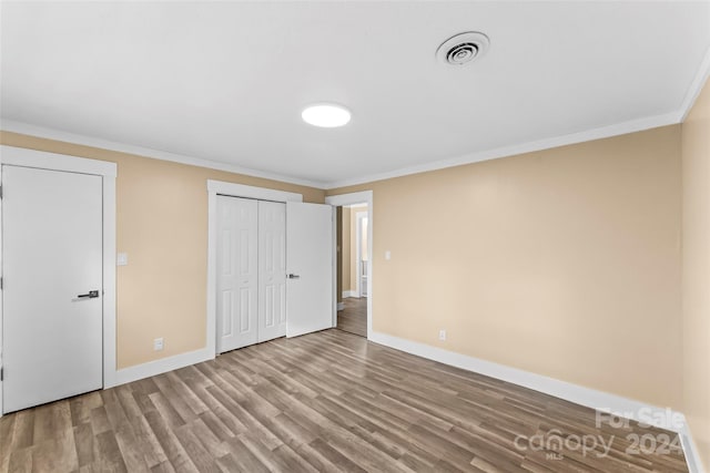 unfurnished bedroom featuring ornamental molding and light hardwood / wood-style flooring