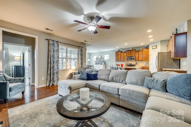 living room featuring ceiling fan and dark wood-type flooring