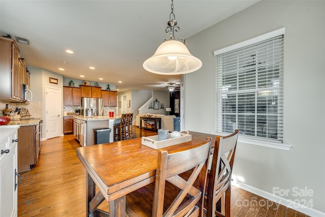 dining space with ceiling fan and light hardwood / wood-style flooring