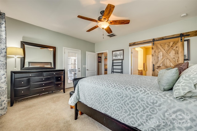 bedroom featuring a barn door, ceiling fan, and light carpet