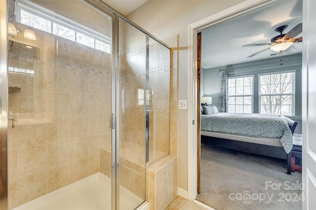 bathroom featuring ceiling fan and a shower with door