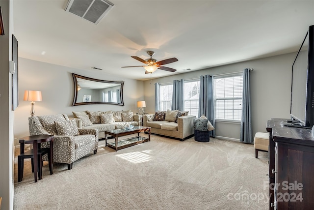 carpeted living room with ceiling fan