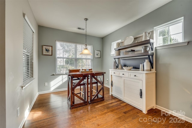 dining room with wood finished floors, visible vents, and baseboards