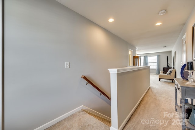 corridor with light carpet, recessed lighting, an upstairs landing, and baseboards