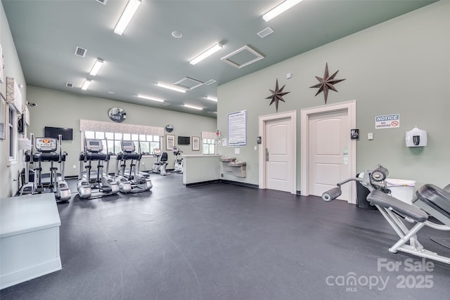 gym featuring attic access and visible vents