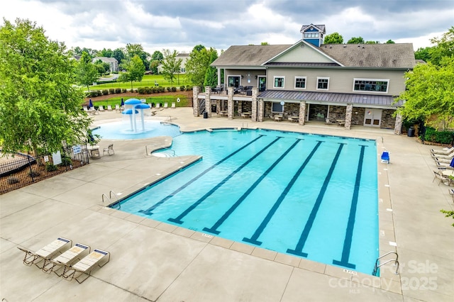 pool with a patio area and fence