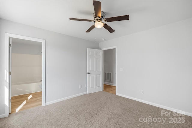 unfurnished bedroom featuring ceiling fan, ensuite bathroom, and light carpet