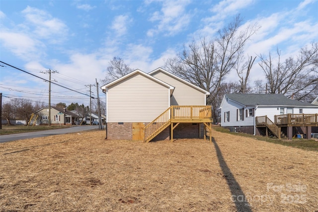 rear view of property with a yard and a deck