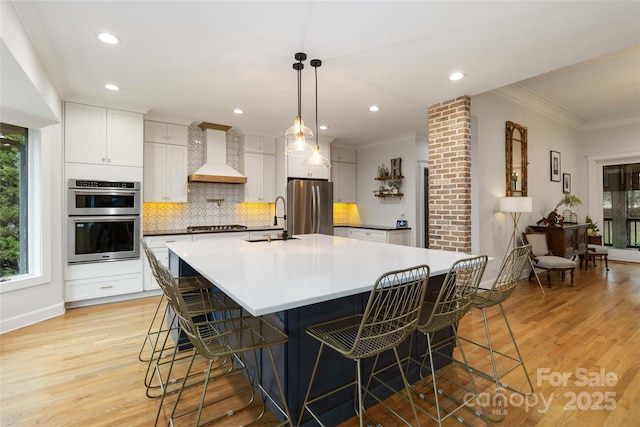 kitchen with a spacious island, a breakfast bar area, custom exhaust hood, stainless steel appliances, and white cabinets