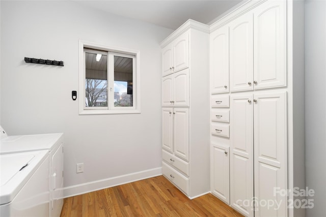 laundry area featuring cabinets, light wood-type flooring, and washer and clothes dryer