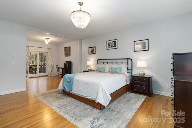 bedroom with a notable chandelier and light wood-type flooring