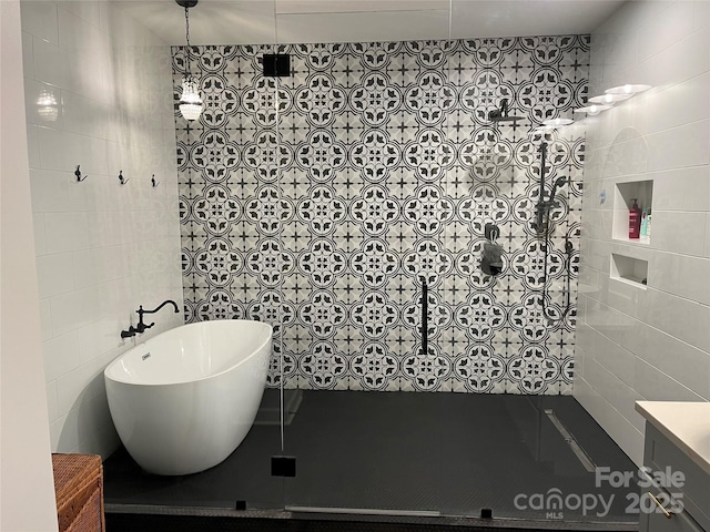 bathroom with tile walls, vanity, and separate shower and tub