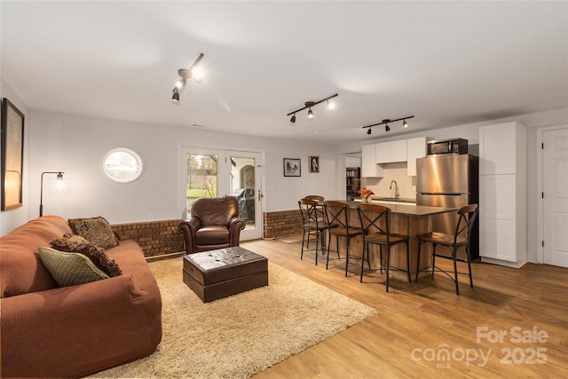 living room with sink and light hardwood / wood-style floors