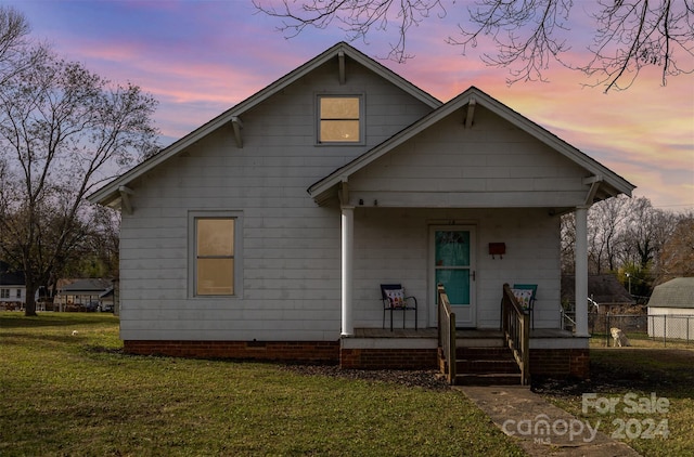 view of front of house with a porch and a yard