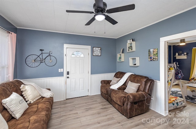 living room featuring crown molding, ceiling fan, and light wood-type flooring