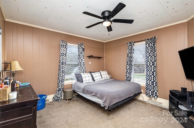 bedroom featuring ceiling fan, carpet floors, ornamental molding, and wooden walls