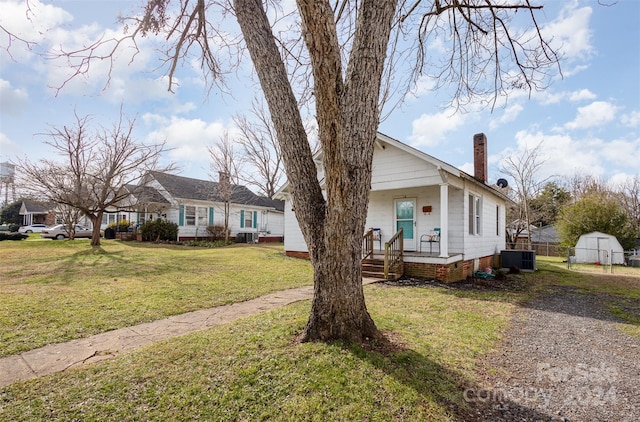 view of front of home with a porch, a front lawn, and central AC unit