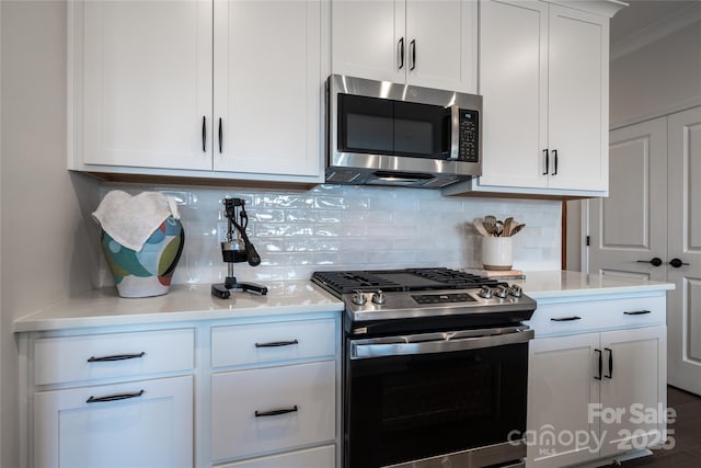 kitchen featuring white cabinetry, light countertops, backsplash, and stainless steel appliances