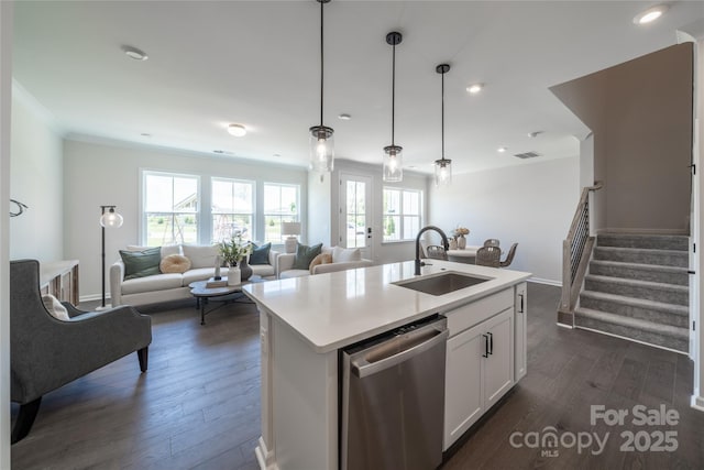 kitchen featuring dark wood finished floors, dishwasher, light countertops, white cabinets, and a sink