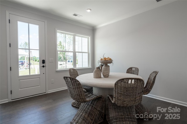 dining room featuring visible vents, baseboards, dark wood-style floors, and ornamental molding