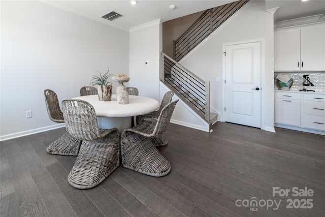 dining space with visible vents, ornamental molding, stairway, baseboards, and dark wood-style flooring