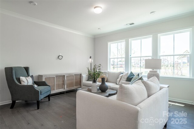 living room with dark wood finished floors, visible vents, plenty of natural light, and crown molding