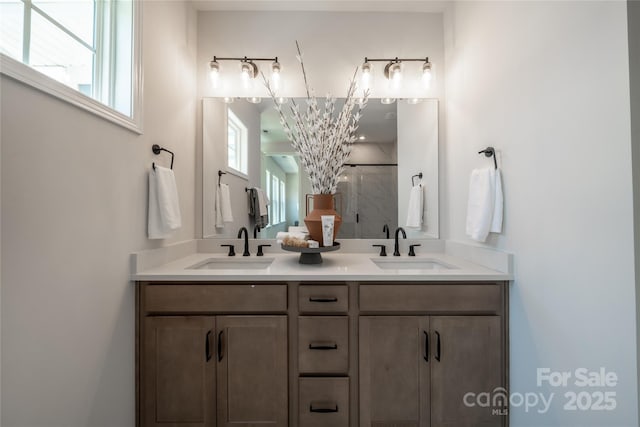 bathroom featuring double vanity, a shower stall, and a sink