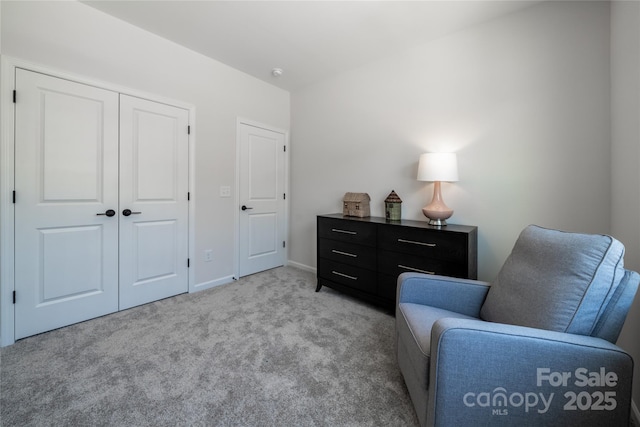 living area featuring baseboards and light carpet