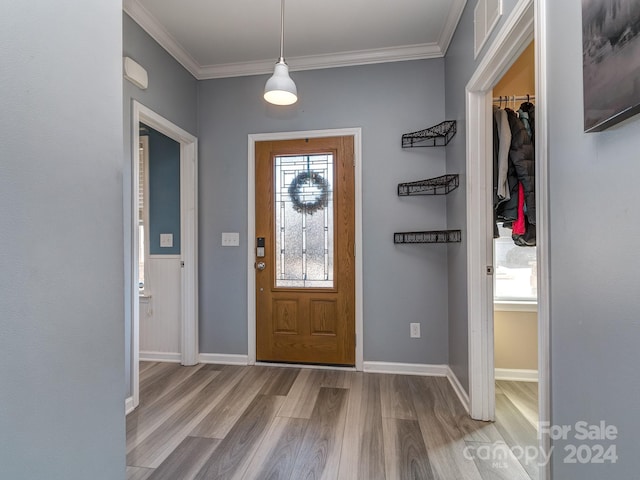 foyer with crown molding and light wood-type flooring