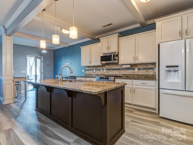 kitchen with a kitchen bar, appliances with stainless steel finishes, sink, decorative light fixtures, and light hardwood / wood-style flooring