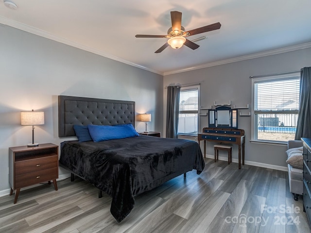 bedroom featuring wood-type flooring, multiple windows, ornamental molding, and ceiling fan