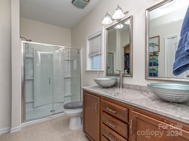 bathroom with tile patterned flooring, vanity, an enclosed shower, and toilet