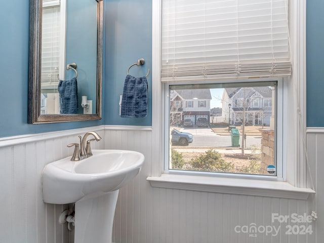 bathroom featuring wood walls and sink