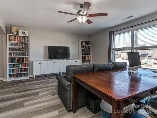 living room with ceiling fan, plenty of natural light, and wood-type flooring