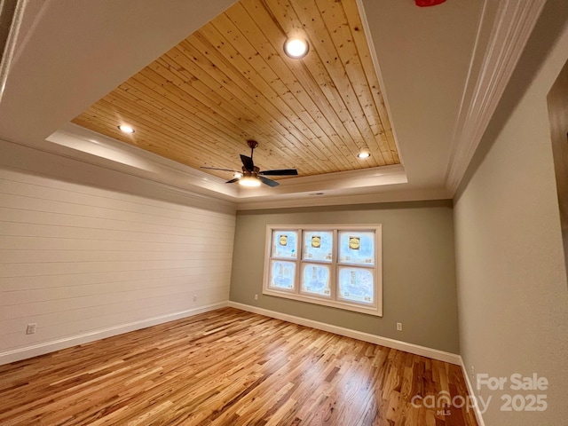 spare room with ornamental molding, ceiling fan, wood ceiling, a raised ceiling, and light hardwood / wood-style flooring