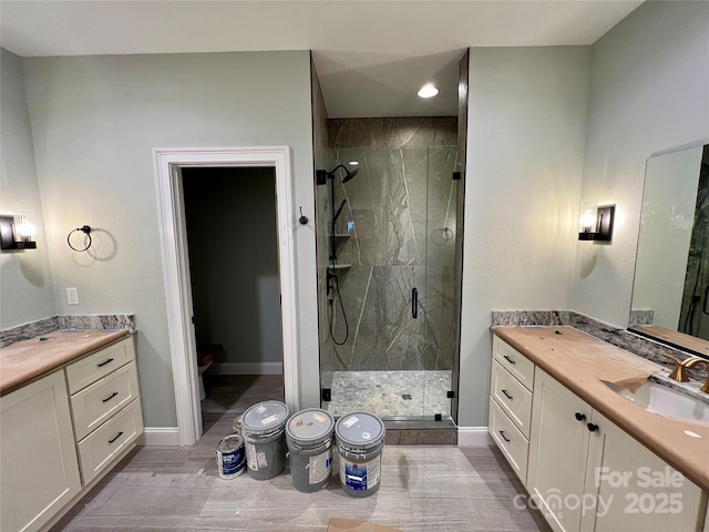 bathroom with a shower with door and vanity